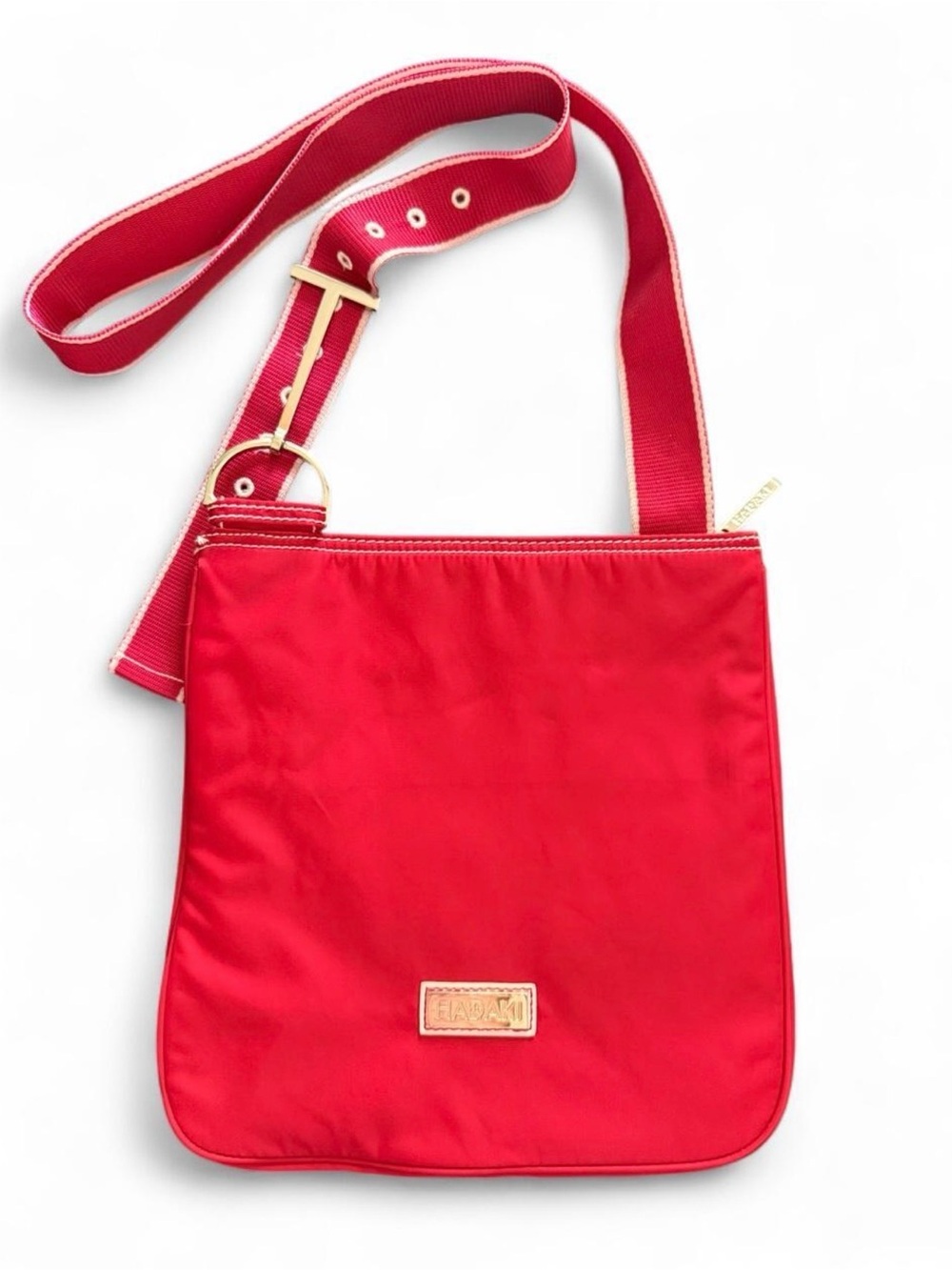 HADAKI red nylon crossbody bag with white stitching. Shiny silver hardware.